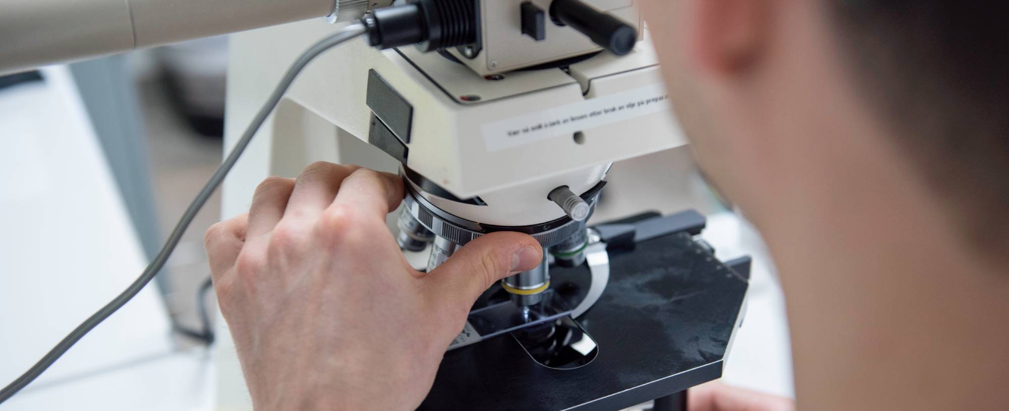 En bioingeniør som er er ferd med å utføre en mikroskopiundersøkelse. 